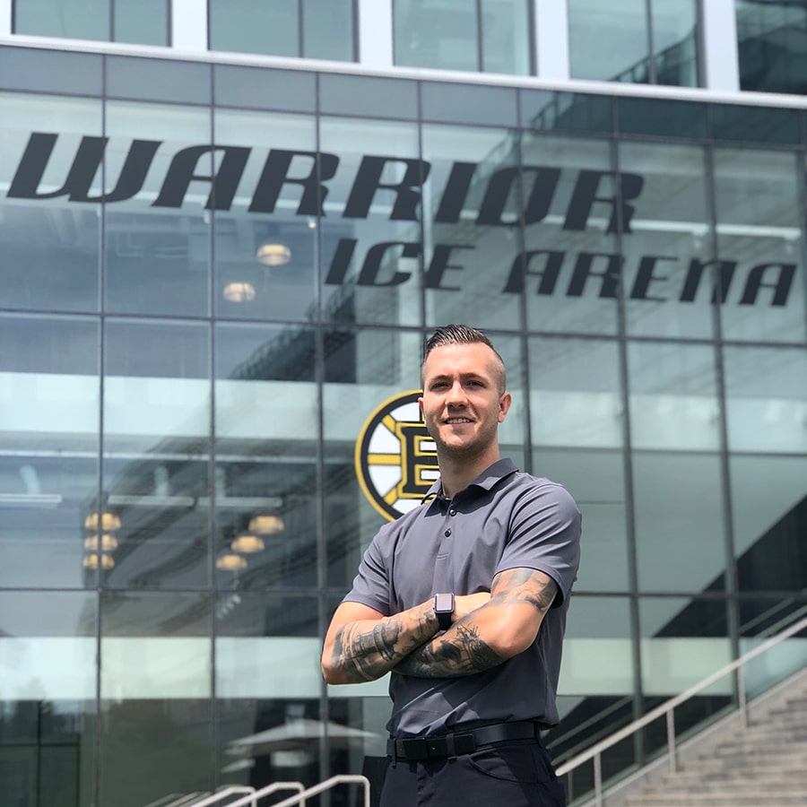 Student standing in front of Warrior Ice Arena.