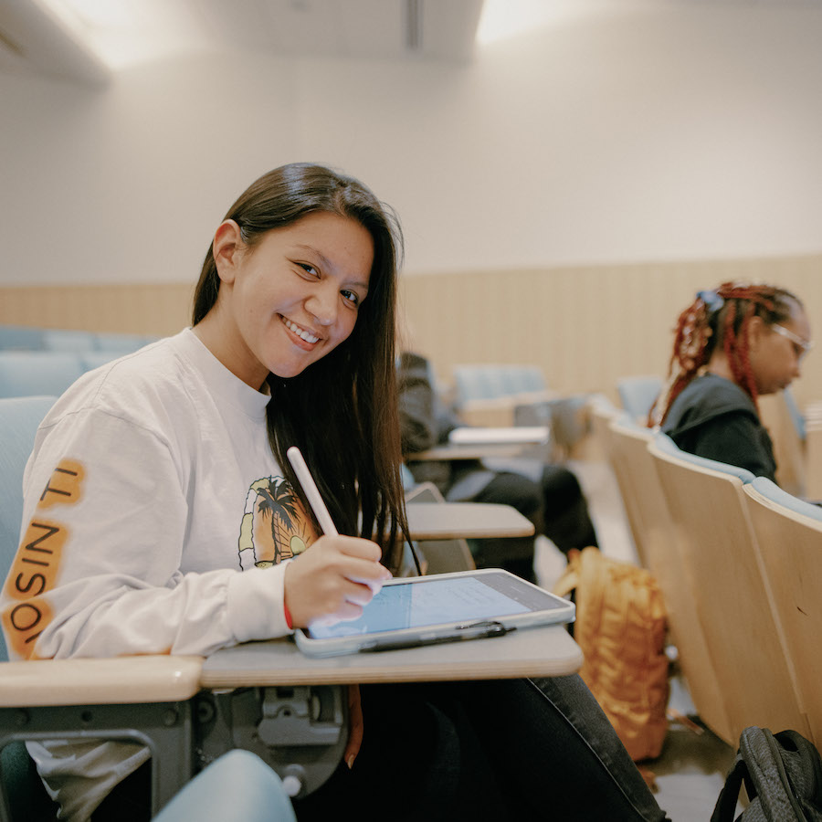 Student sitting in a classroom taking notes