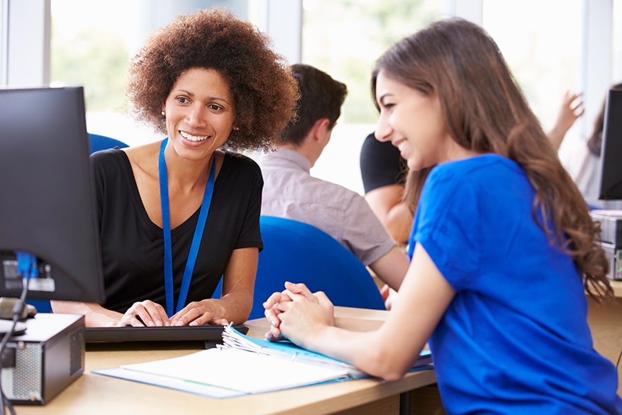 medical advisor looks on computer screen with health care assistant