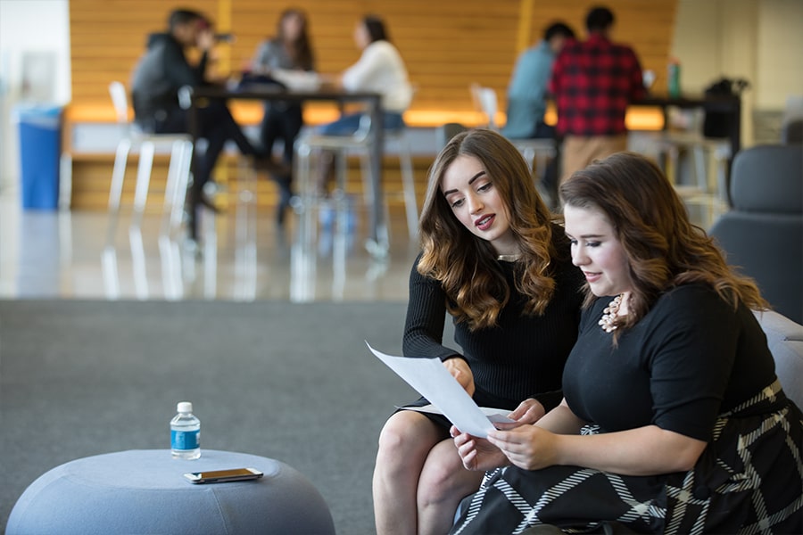 2 girls study in university hall.