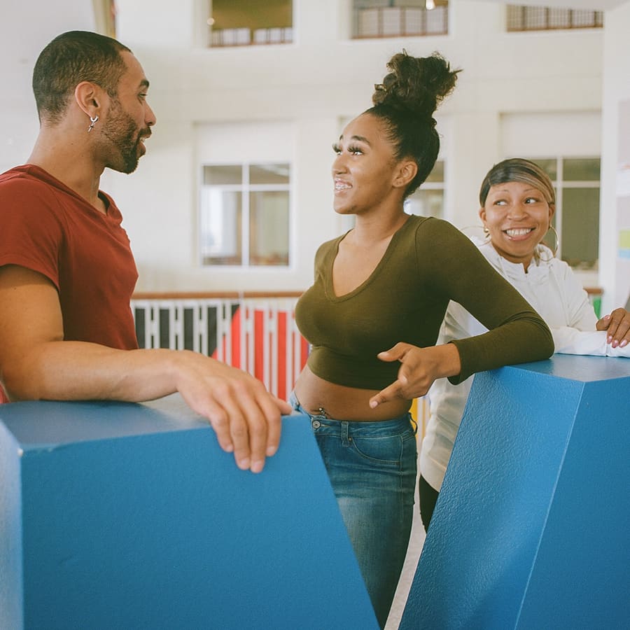 3 students pose by UMB in Campus Center