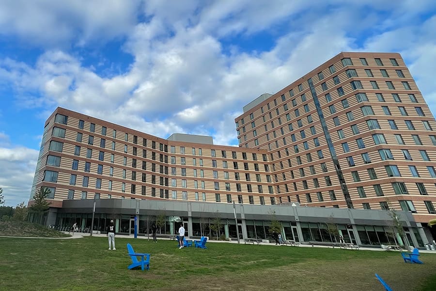 Residence Hall with students on lawn in front.