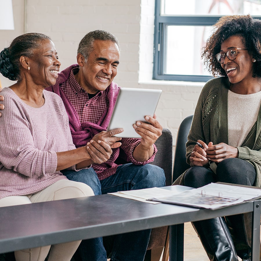 elderly Black couple  consulting with a female Black gerontology worker