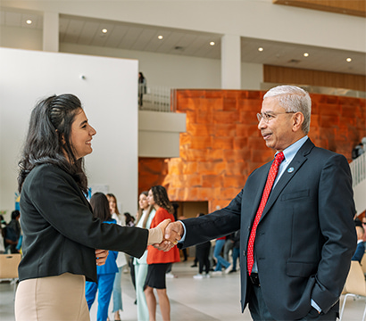 Graduate student shaking hands with professor.