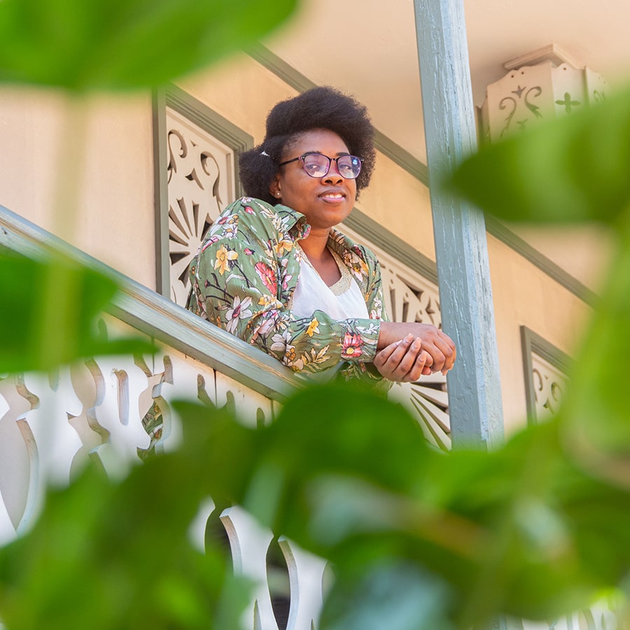 A photo of a smiling woman on the first floor of a house in Petion-ville, Haiti.