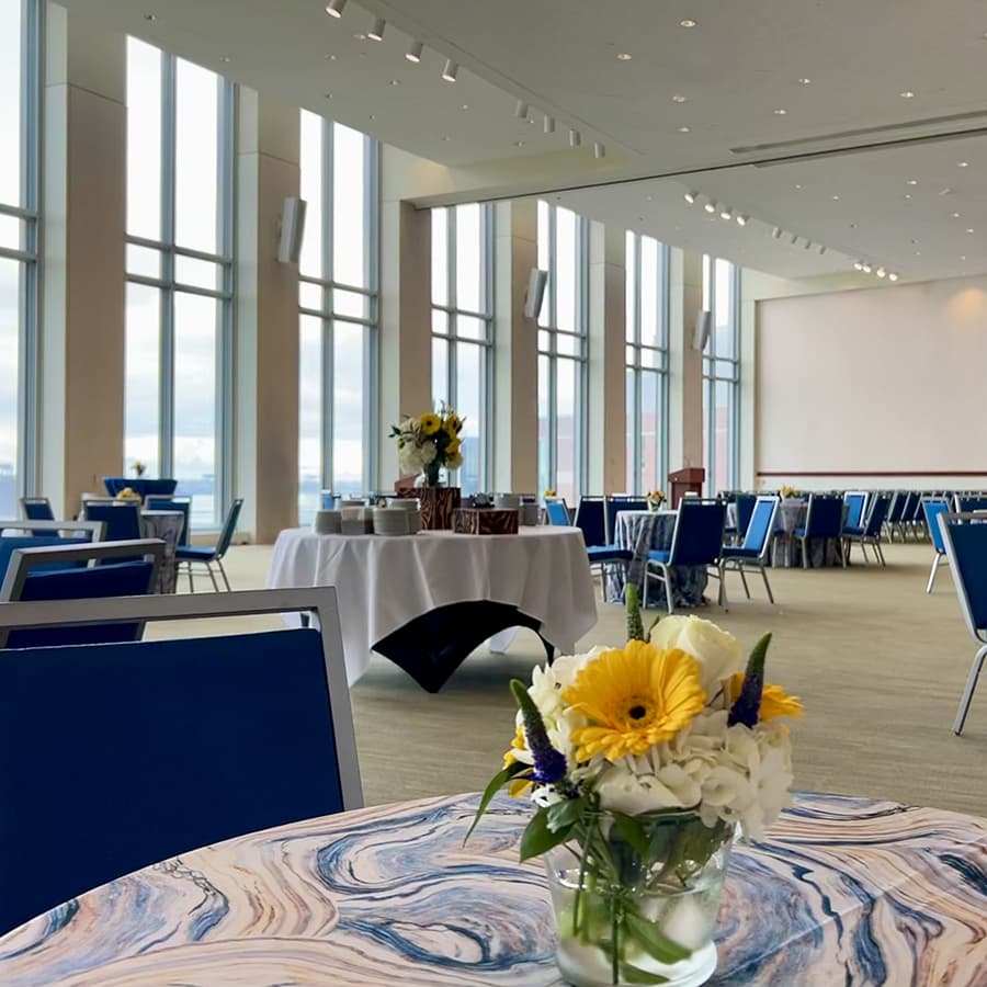 Ballroom full of round tables decorated with flowers.