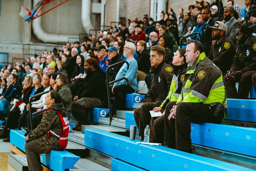 Students, faculty, and first responders in the Clark Athletic Center bleachers listening to presentation