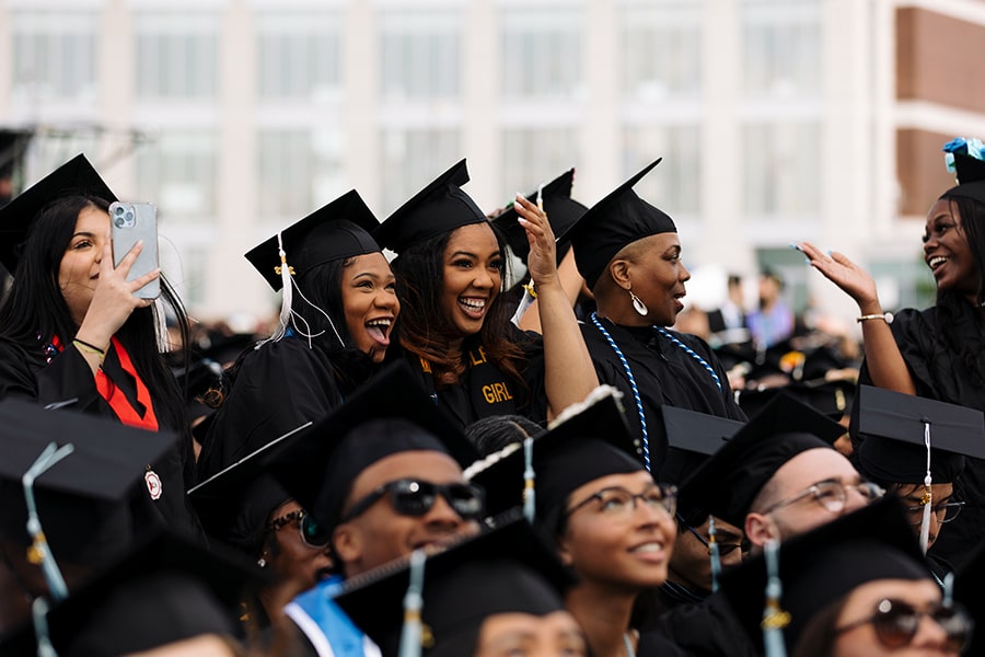 Graduating Students wearing graduation caps celebrating